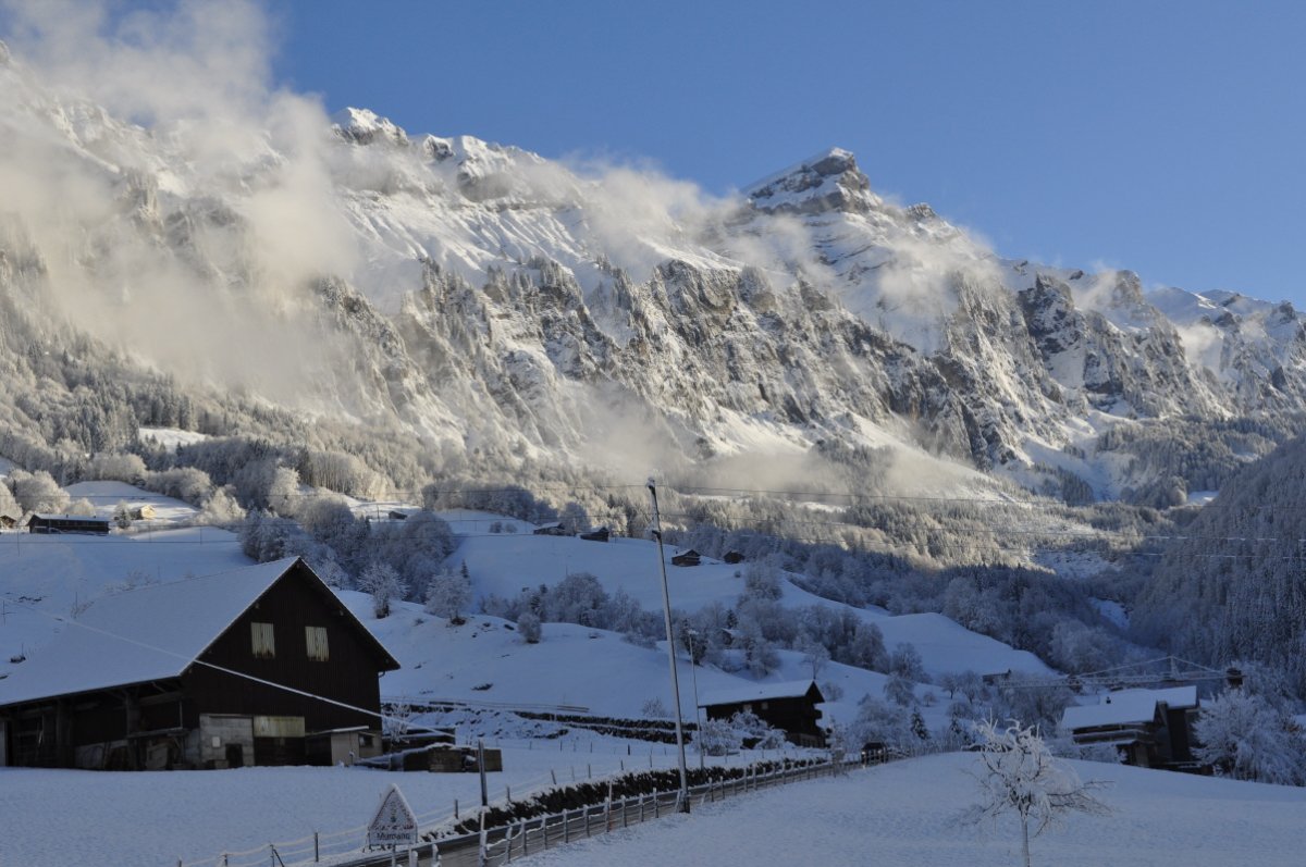 eine verschneite Bergkette mit Talboden im Vordergrund